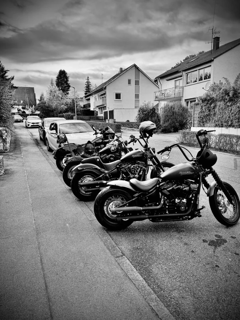 Mehrere Motorräder in einer Straße, fotografiert in Schwarz-Weiß